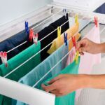 Person Hanging Wet Cloth On Clothes Line