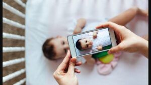 Mama realizează o fotografie copilului cu ajutorul smartphonului