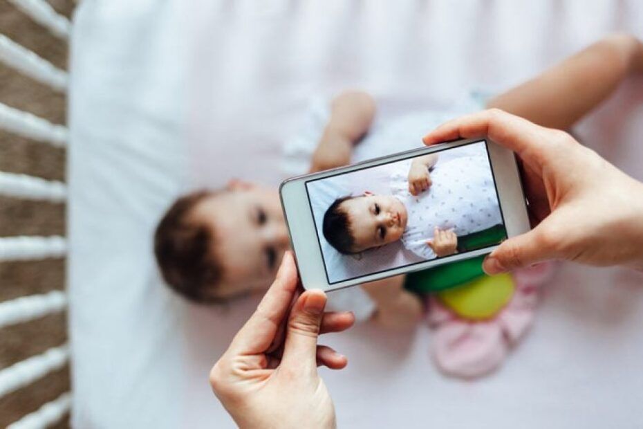 Mama realizează o fotografie copilului cu ajutorul smartphonului